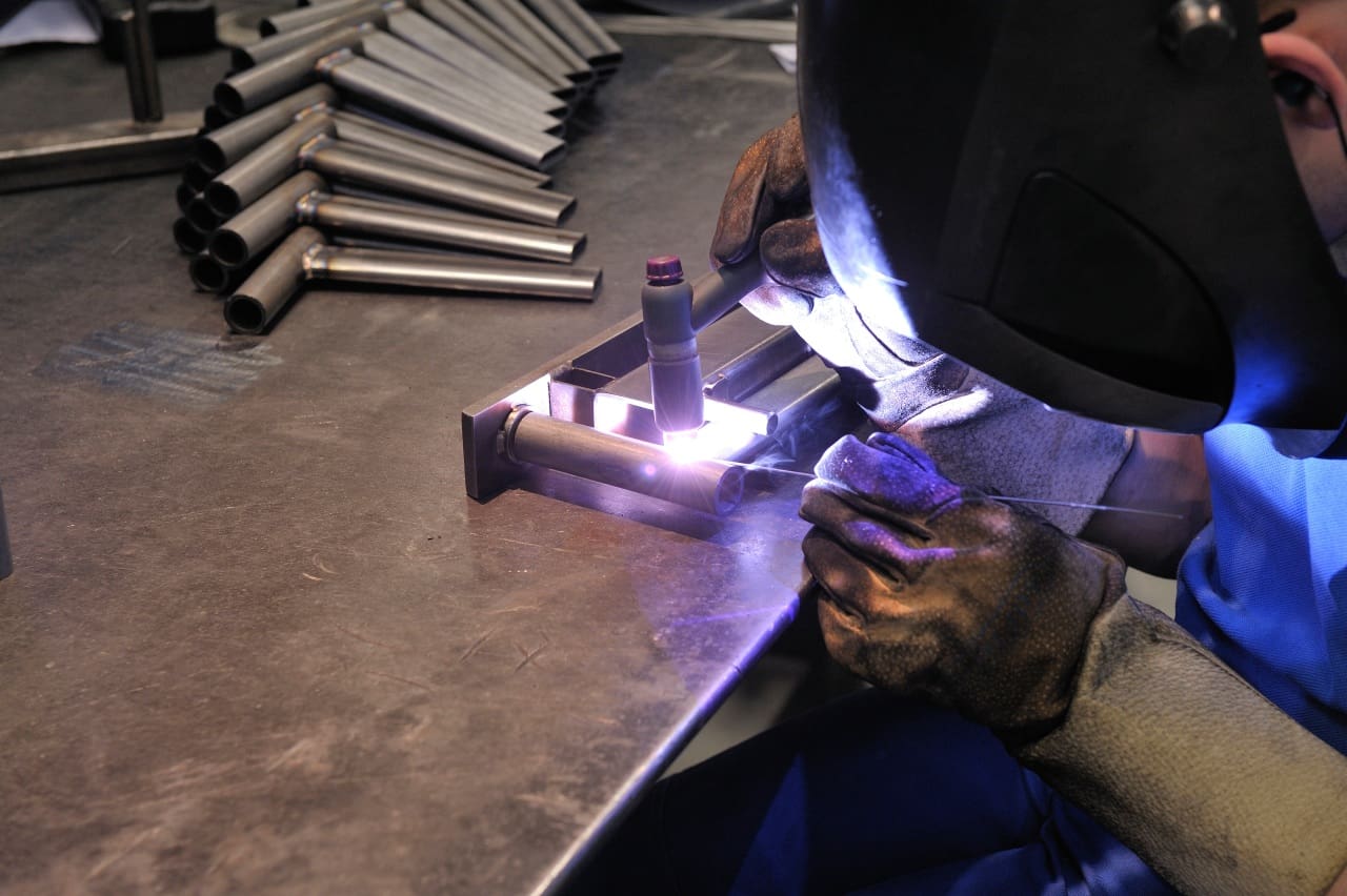 Welder wearing a mask welding metal.