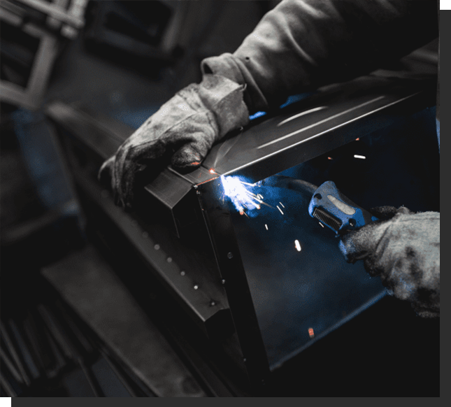 A person welding metal in an industrial setting.