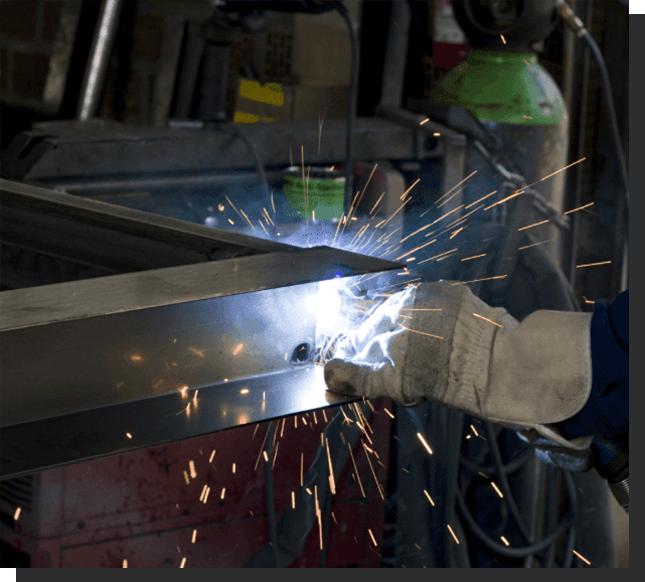 A person welding metal with sparks flying from the hands.