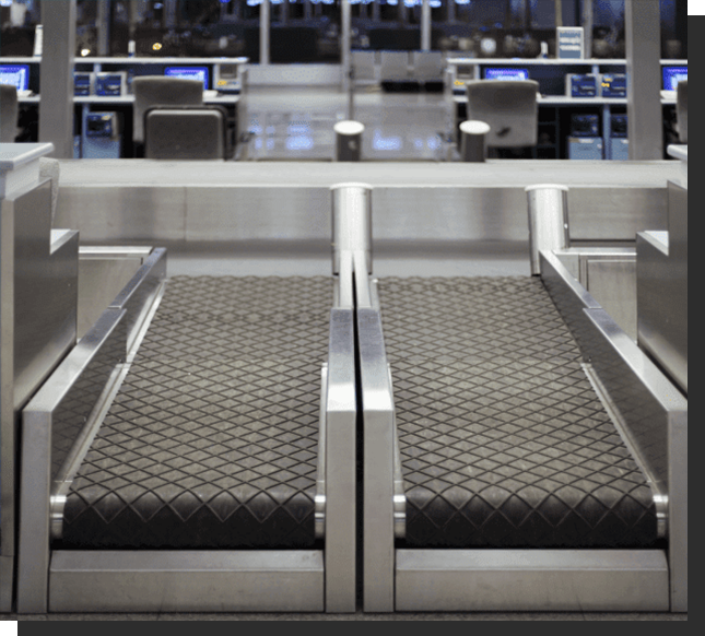 A baggage claim area with luggage carts and benches.